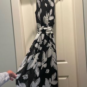 Sleeveless ankle dress. Tie at waist, zipper back. Fully lined. Black w/ flowers